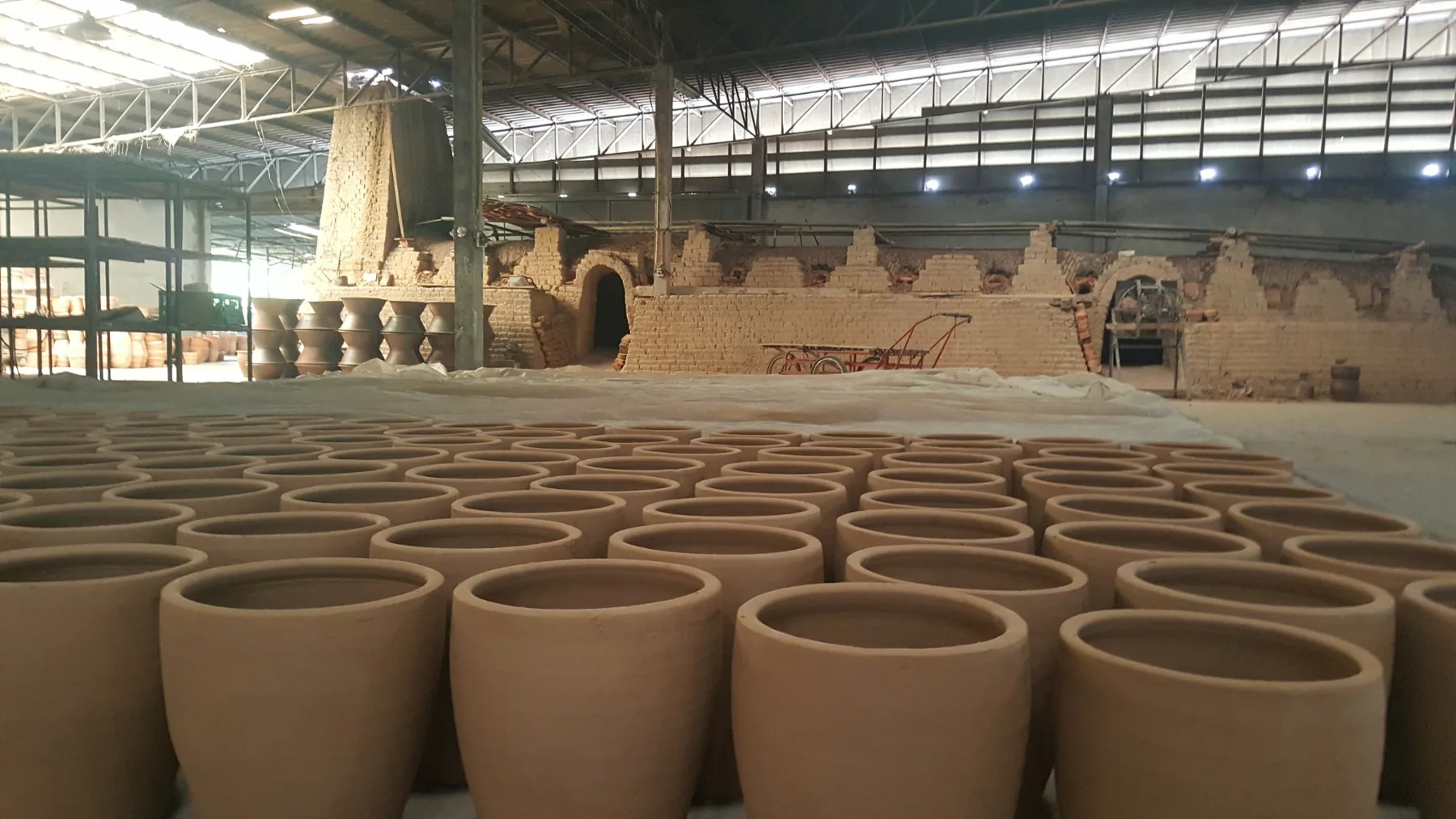 Freshly formed clay planters arranged for drying